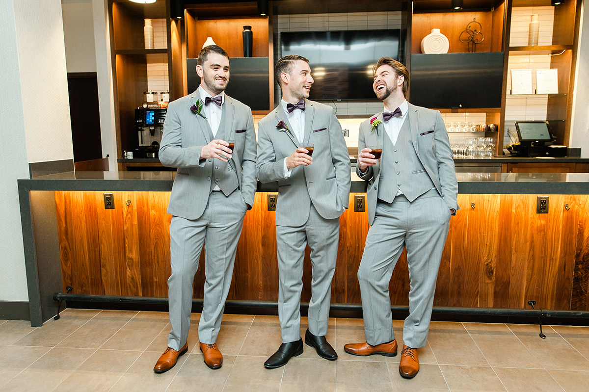 Three groomsmen enjoying themselves at the bar