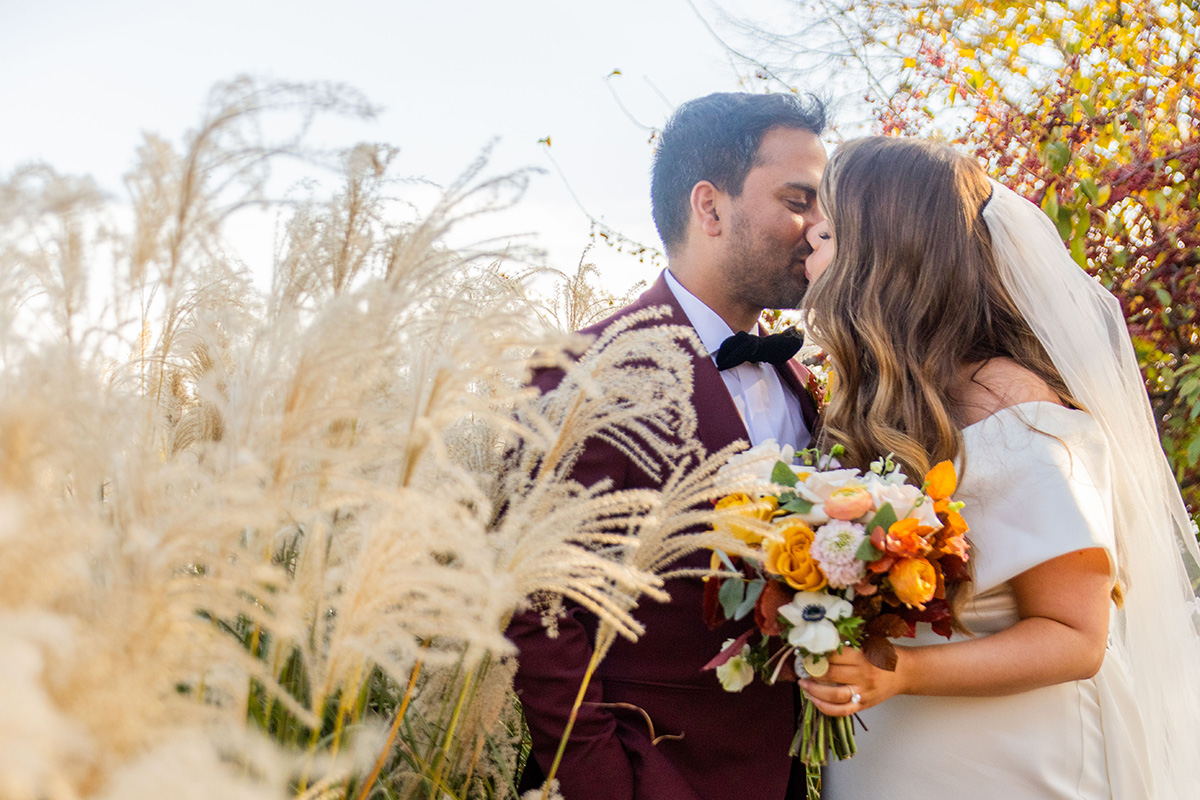 Married couple kissing near a field